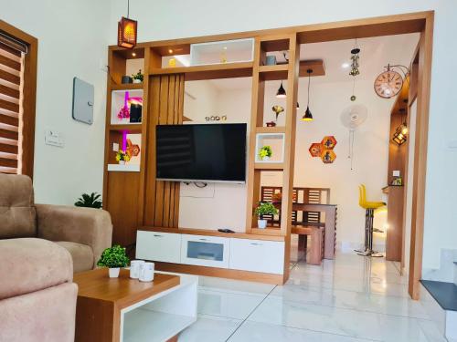 a living room with a flat screen tv on a wall at Milaano Orchids, Service Villa, Kammana Mananthavady in Wayanad