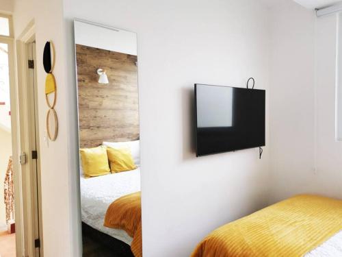 a bedroom with a bed and a tv on a wall at Preciosa Habitacion G in Guatemala