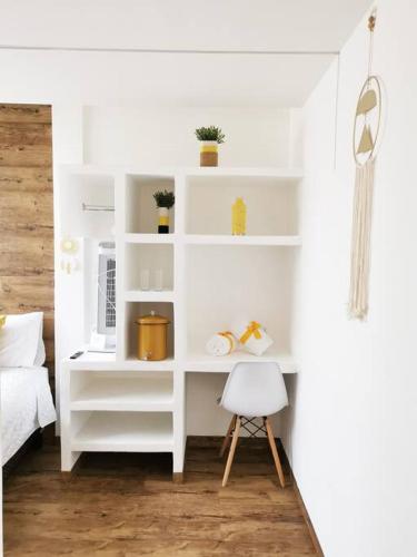 a bedroom with white shelves and a white chair at Preciosa Habitacion G in Guatemala