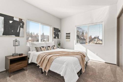 ein weißes Schlafzimmer mit einem Bett und zwei Fenstern in der Unterkunft Brand New 2 Bed 2 Bath Near Perry District and DT in Spokane