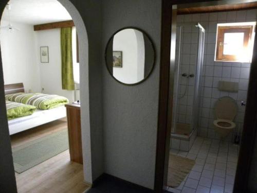 ein Bad mit einem Spiegel und ein Bad mit einem Bett in der Unterkunft Haus Renate in Lermoos