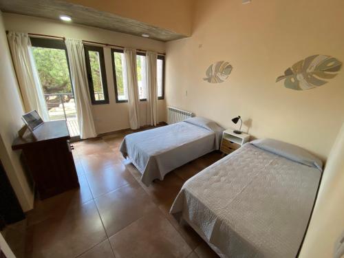 a hotel room with two beds and a window at Andelka-Chumamaya Merlo San Luis in Merlo