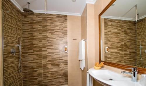 a bathroom with a shower with a sink and a mirror at La Casona de Lazúrtegui in Ribadeo
