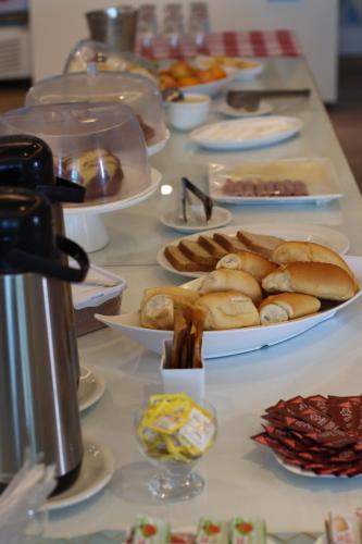 a buffet with plates of food on a table at Golf Ville Resort Brisa do Golf -Apartamentos e Cobertura in Aquiraz
