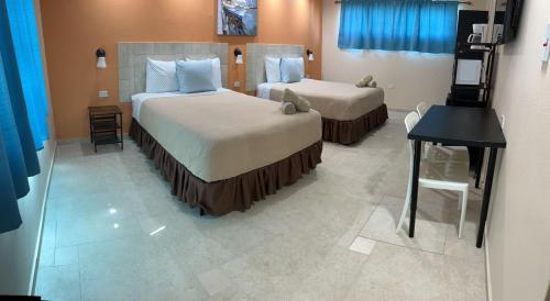 a hotel room with two beds and a desk at Aqua by Dreams Hotel 