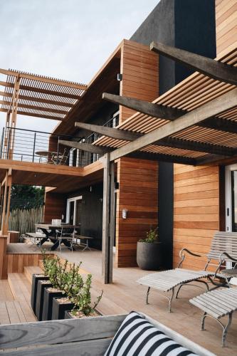 a patio with benches and tables on a building at The Oyster Box Beach House by The Oyster Collection in Kenton on Sea