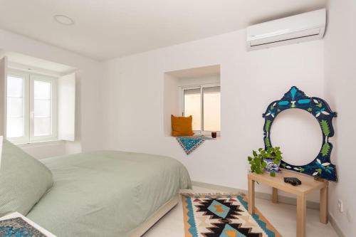une chambre blanche avec un lit et un miroir dans l'établissement A Treat in Belém, à Lisbonne