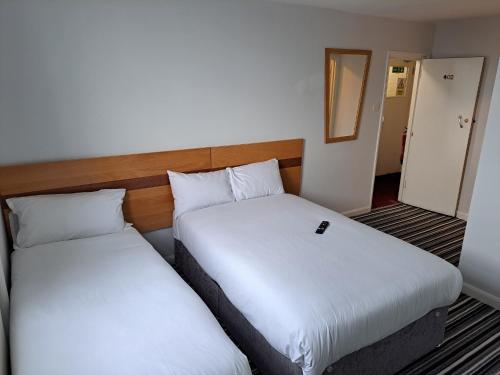 2 Betten in einem Hotelzimmer mit Spiegel in der Unterkunft Palace Court Hotel in London