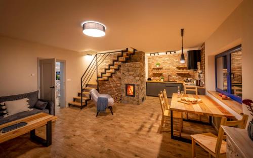 ein Wohnzimmer mit einem Tisch und einem Steinkamin in der Unterkunft Winny Domek w Radochowie in Lądek-Zdrój