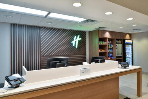 a reception desk in an office with a cross on the wall at Holiday Inn Hotel & Suites Overland Park-Convention Center by IHG in Overland Park