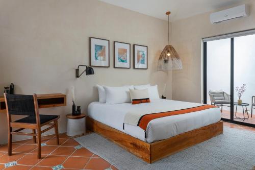 Schlafzimmer mit einem Bett, einem Schreibtisch und einem Stuhl in der Unterkunft Aalada Playa del Carmen in Playa del Carmen