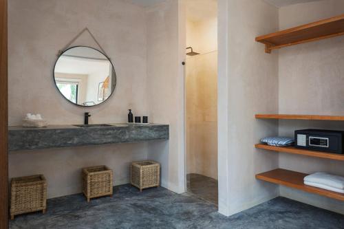 een badkamer met een wastafel en een spiegel bij Aalada Playa del Carmen in Playa del Carmen