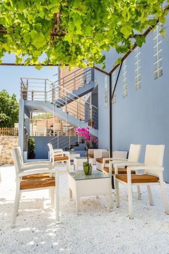 a group of chairs and tables in front of a building at New Azzurro Deluxe in Limenaria