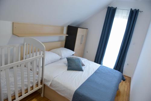 a small bedroom with a crib and a white bed at Holiday home Maša - Kupres in Kupres