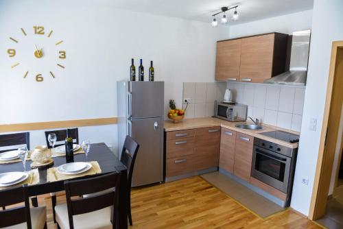a kitchen with a table and a stainless steel refrigerator at Holiday home Maša - Kupres in Kupres