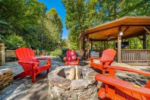 three red chairs sitting around a fire pit in a yard at Oasis In the Mountains in Murphy
