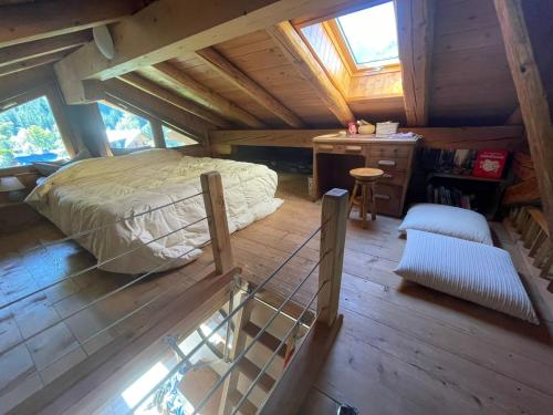 een slaapkamer op zolder met een bed en een bureau bij Magnifique chalet dans la vallée de Chamonix in Servoz