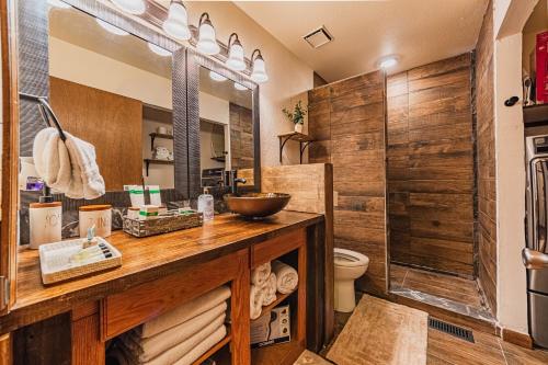 ein Badezimmer mit einem Waschtisch aus Holz und einem WC in der Unterkunft Blissful Mountain Escape in Woodland Park
