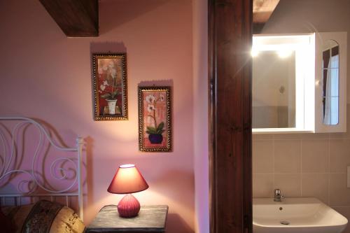 a bathroom with a sink and a lamp on a table at Agriturismo Regina di fiori in Monte Porzio