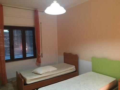 ein kleines Zimmer mit 2 Betten und einem Fenster in der Unterkunft Appartamento relax a Catanzaro Lido in Catanzaro