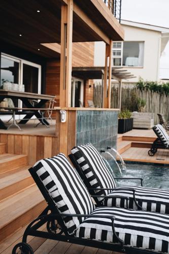 two black and white chairs sitting on a patio at The Oyster Box Beach House by The Oyster Collection in Kenton on Sea