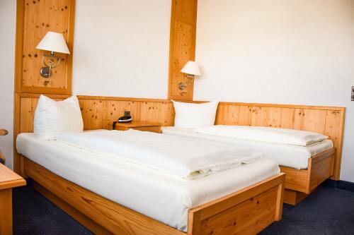 two beds in a room with wooden walls at Hotel Bergwiesen in Lohr am Main
