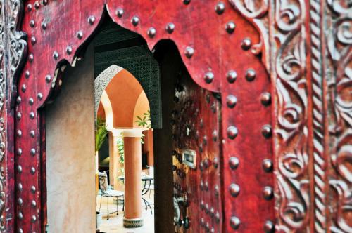 Una puerta roja con un montón de cuentas. en Riad Bensaid, en Marrakech