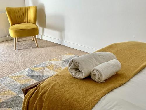 uma cama com uma toalha com uma cadeira em Central Darlington Apartment With Parking em Darlington