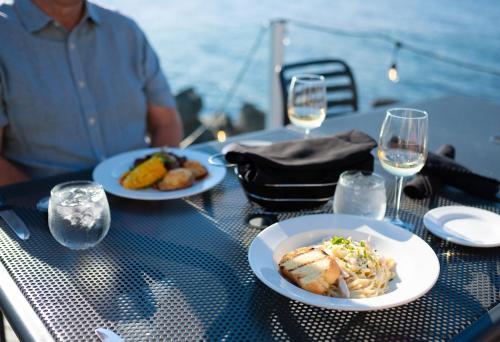 a table with two plates of food and glasses of wine at Rodd Miramichi in Miramichi