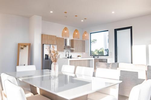 a white dining room with a white table and white chairs at Ocean view luxury Villa, Private Pool 4BD 8PPL in Playa Venao