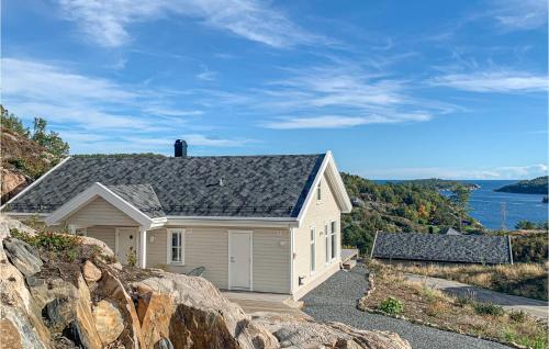 a white house with a gray roof on a hill at Beautiful Home In Risør With Kitchen in Risør