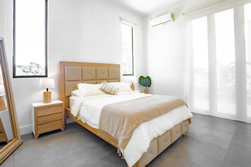 a bedroom with a large bed with white walls and windows at Ocean view luxury Villa, Private Pool 4BD 8PPL in Playa Venao