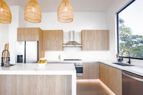 a kitchen with wooden cabinets and white counter tops at Ocean view luxury Villa, Private Pool 4BD 8PPL in Playa Venao