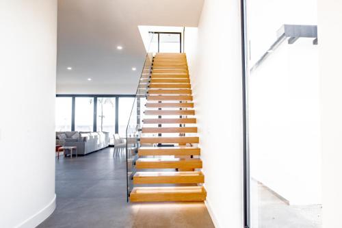 a staircase in a house with white walls and wooden steps at Ocean view luxury Villa, Private Pool 4BD 8PPL in Playa Venao