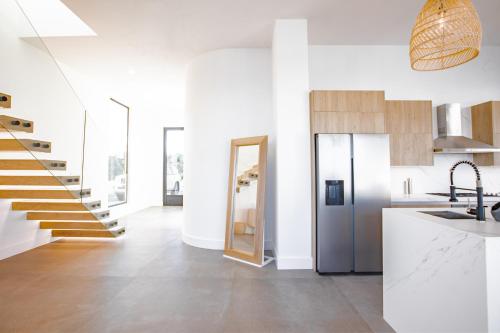 a kitchen with a staircase and a kitchen with white walls at Ocean view luxury Villa, Private Pool 4BD 8PPL in Playa Venao
