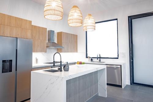 a kitchen with white countertops and two pendant lights at Ocean view luxury Villa, Private Pool 4BD 8PPL in Playa Venao