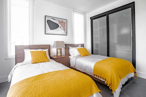 a bedroom with two beds with yellow sheets and a window at Ocean view luxury Villa, Private Pool 4BD 8PPL in Playa Venao