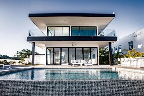 a house with a swimming pool in front of a house at Ocean view luxury Villa, Private Pool 4BD 8PPL in Playa Venao