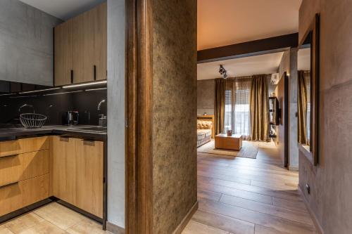 a kitchen with wooden cabinets and a living room at Bella Roe Premium Apartments in Belgrade