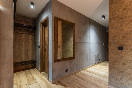an empty hallway with wooden floors and a mirror on the wall at Bella Roe Premium Apartments in Belgrade