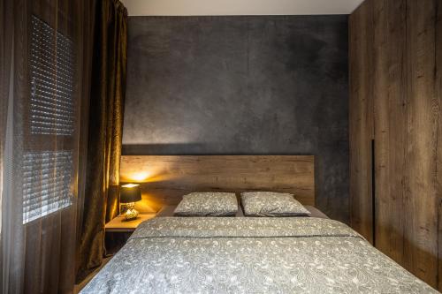 a bedroom with a bed and a wooden wall at Bella Roe Premium Apartments in Belgrade