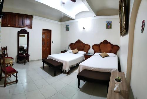 Habitación de hotel con 2 camas y mesa en Hotel Patio Pombo en Oaxaca de Juárez