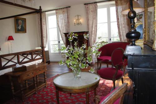 a living room with a vase of flowers on a table at Château de Pommeuse in Pommeuse