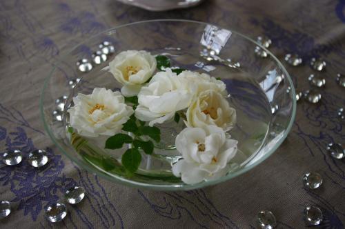 a glass bowl filled with white flowers on a table at Château de Pommeuse in Pommeuse