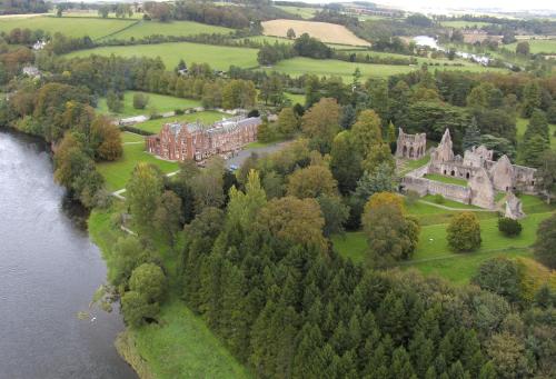 an aerial view of a mansion next to a river at Dryburgh Abbey Hotel in Melrose