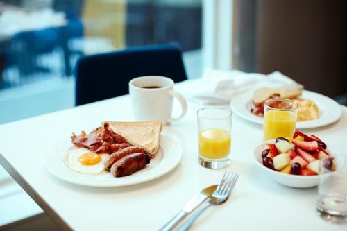 a table with two plates of breakfast foods and a cup of coffee at Holiday Inn Newport News - Hampton, an IHG Hotel in Newport News