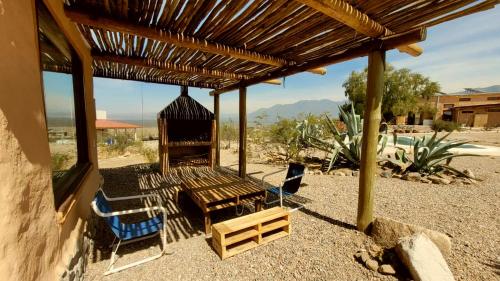 uma pérgola de madeira com duas cadeiras e uma mesa em CABAÑAS KONDUR Elementos em Luján de Cuyo