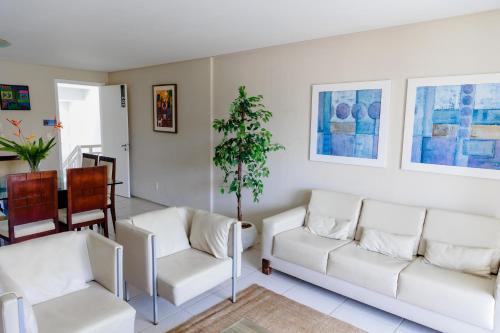a living room with two white couches and a table at Atlantic Palace Family inn in Aquiraz