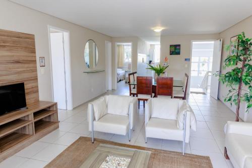 a living room with a table and chairs and a television at Atlantic Palace Family inn in Aquiraz