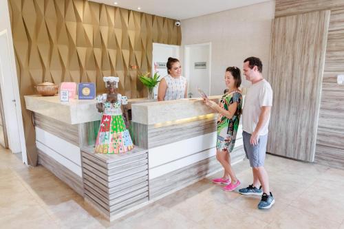 a group of people standing in front of a counter at Atlantic Palace Family inn in Aquiraz